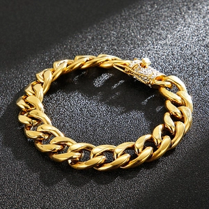 Close-up of a thick gold Cuban link bracelet featuring a luxury pavé zircon buckle clasp