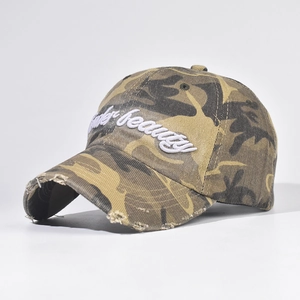 Détail d'une casquette de baseball camouflage vintage avec bord usé et broderie