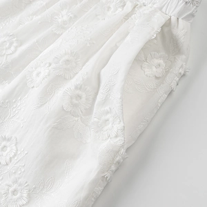 Detail of 3D floral embroidery on white short-sleeved shirt with side pocket detail
