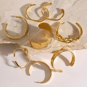 Detail of 18K gold-plated stainless steel bangles with hammered and wavy textures