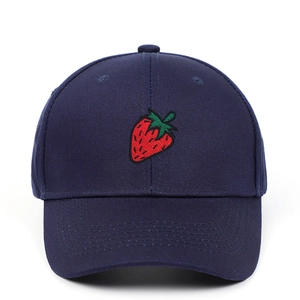Detailed close-up of strawberry embroidery on a navy blue cotton baseball cap