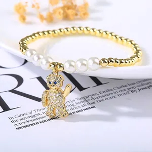 Detailed view of beaded bracelet with pearl accents and crystal-studded bear charm