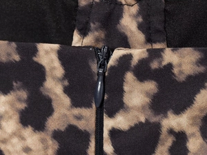 Macro view of a seamless invisible zipper on leopard print woven fabric texture
