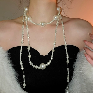 Detail of multi-layer pearl necklace showing elegant draping and glossy white beads