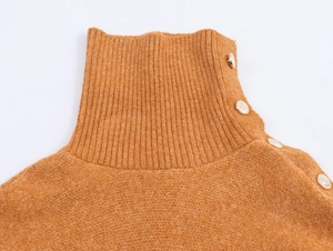 Dettaglio maglione arancione a collo alto con bottoni dorati vintage sulla spalla