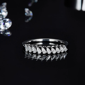 Close-up of teardrop moissanite stones set in 925 silver on a black reflective surface