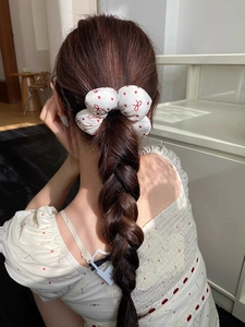 Detail of floral sponge hair scrunchie with red heart print worn by a model