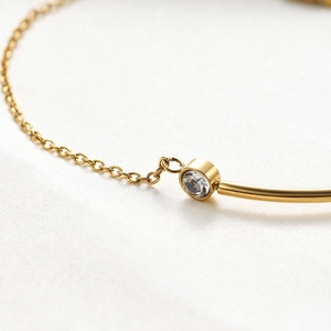 Macro shot of 18K gold plated stainless steel chain bracelet with a single round zircon