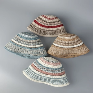 Flat lay of four colorful crochet striped bucket hats with breathable hollow weave design