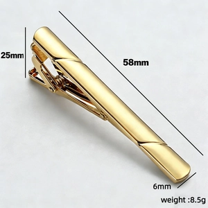 Macro detail of gold-plated tie clip with classic diagonal texture and mirror finish