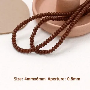 Dettaglio di perline marroni 4x6mm con foro da 0,8mm per creazione gioielli fai-da-te