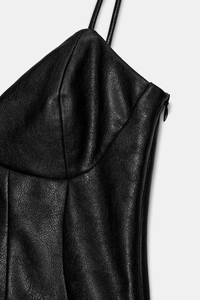 Dettaglio vestito nero in finta pelle con spalline sottili e cerniera laterale nascosta