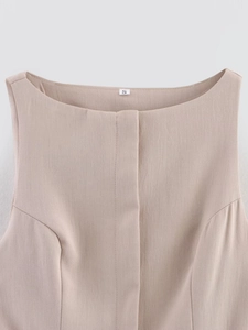 Close-up of crew neckline on a light beige dress with premium fabric texture and size label