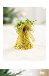 Detail of golden hollow Christmas bell with a mesh bow, pine needles and a mini pinecone