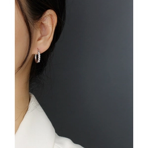 Close-up of geometric S925 silver hoop earrings with inset diamonds worn by a model