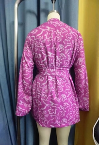 Détail du dos du haut violet à manches longues avec imprimé floral et ceinture assortie