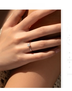 Detail of princess cut moissanite ring in silver band worn on a model hand