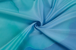 Detailed view of the blue-green gradient fabric showing a fine twill weaving texture