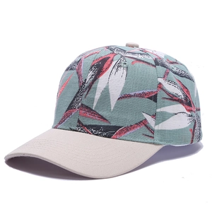 Detail of tropical leaf print on green baseball cap with a beige brim contrast