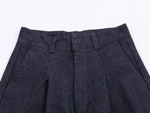 Detailansicht der dunkelblauen Denim-Jacke an der Taille mit präzisen Nähten und Metall