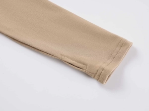 Detailed close-up of tight-knit sleeve cuffs with thumbhole design in light khaki