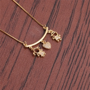 Gold necklace with two boys, one girl, and a zircon heart pendant on wooden background