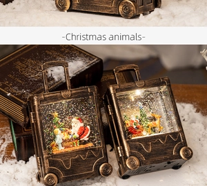 Close-up of vintage bronze suitcase lantern with swirling glitter and Santa miniature