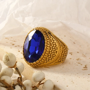 Vintage gold plated stainless steel ring with oval blue gemstone and textured band