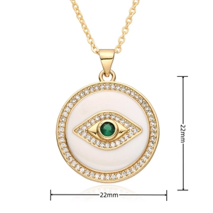 Macro detail of 22mm gold evil eye pendant with green stone and white zircon stones