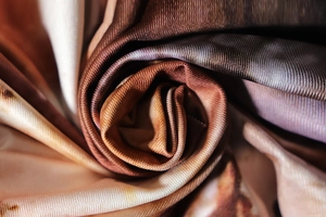 Détail macro du tissu soyeux avec impression dégradée de marron et de beige