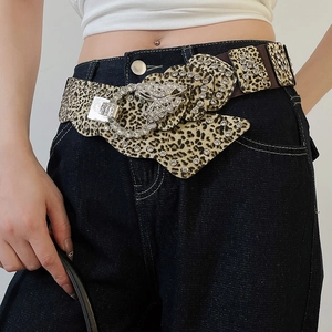 Detail of leopard print leather belt with crystal butterfly buckle and wavy edges