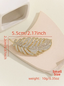 Detail of a small gold feather brooch with zircon crystals, size 5.5cm by 2.2cm