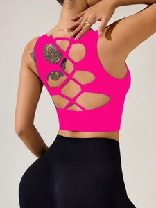 Détail macro du design dos croisé ajouré sur le soutien-gorge de sport rose néon