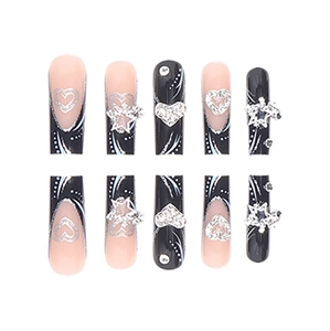 Black and nude press-on nails with silver heart and star charms on white background