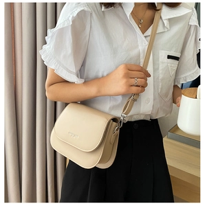 Borsa a sella beige alla moda in pelle PU portata a tracolla su camicia e gonna nera