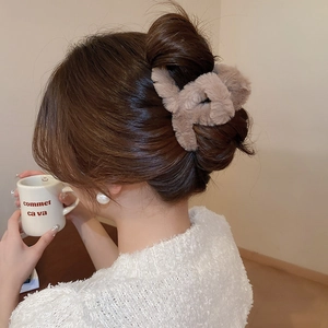 Rear view of model wearing a plush brown coffee faux fur hair claw clip for a messy bun