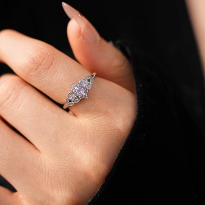 Macro detail of silver wheat crown ring featuring purple zircon and hollow engraving