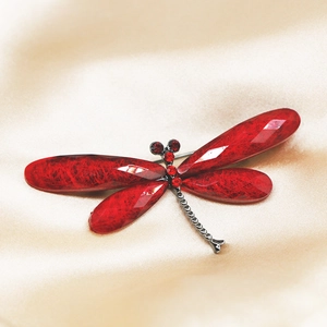 Elegant colorful dragonfly brooch with red crystal wings on champagne satin background