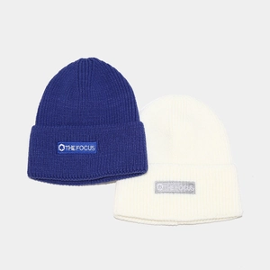 Royal blue and off-white ribbed knit beanies with embroidered logo labels for winter style