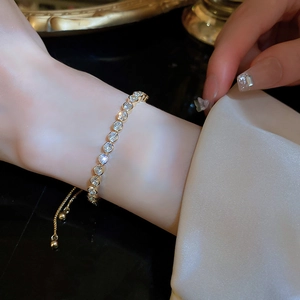 Close-up of adjustable wave bracelet with gold finish and sparkling round-cut crystals