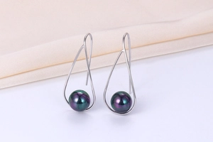 Macro shot of S925 silver hook earrings with iridescent dark purple shell pearls