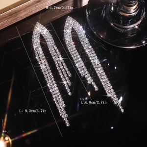 Macro detail of long silver rhinestone tassel earrings with precise size dimensions
