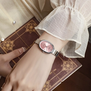 Close-up of elegant silver quartz watch with pink oval dial worn on woman's wrist