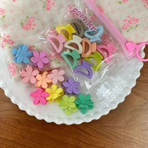 Colorful matte flower hair claws in macaron tones on a decorative ceramic plate