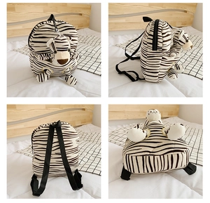 Detail view of plush zebra print tiger backpack showing zippers and 3D features