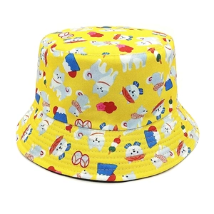 Dettaglio di cappello alla pescatora giallo con motivi di cani e monte Fuji nipponico