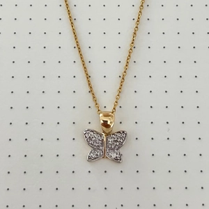 Detailed close-up of a two-tone butterfly pendant with shimmering micro-pave crystals