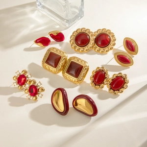 Set of vintage gold stainless steel earrings with red resin and agate in artistic lighting
