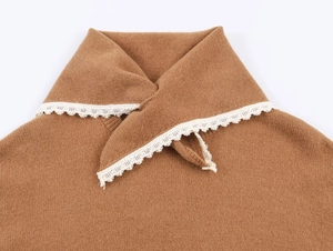 Détail du haut en tricot marron avec dentelle blanche au col et texture en peluche douce