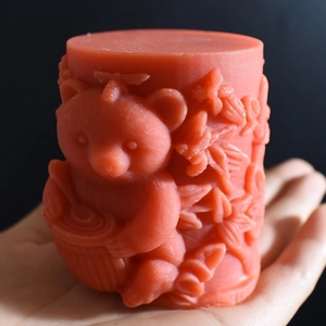 Detail of a red honey bear cylinder mold with intricate leaf and flower relief patterns